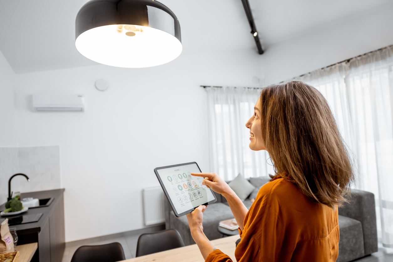 femme controlant un objet connecté avec sa tablette digitale
